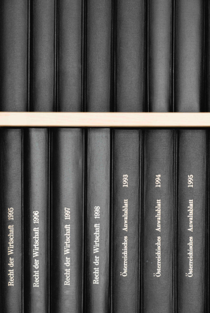 Detailaufnahme Kanzlei-Bibliothek schwarze Buchrücken im Regal